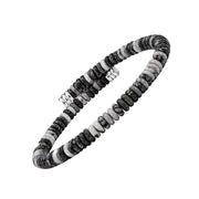 Angled view of a black, grey and white stone disc bead bracelet with marbled detailing and silver-tone end caps