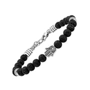 Angled view of a black lava stone bead bracelet with a silver-tone Hamsa hand centerpiece and textured spacers